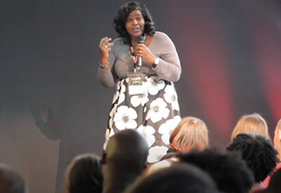 Dr. Aderin-Pocock gives a Ted Talk on stage in front of an audience.