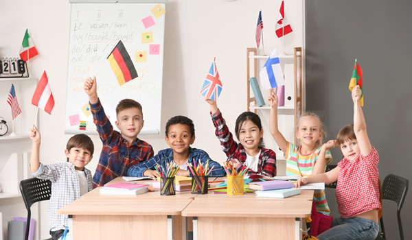 Elementary school children hold up flags from around the world.