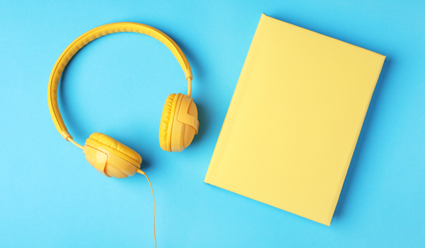 yellow headphone and a book with a yellow cover on a blue background