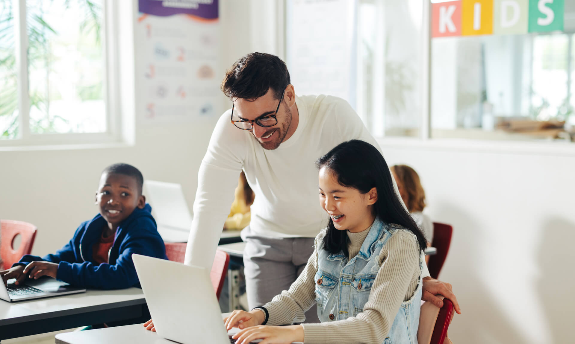 Teacher guiding student with computer-based learning