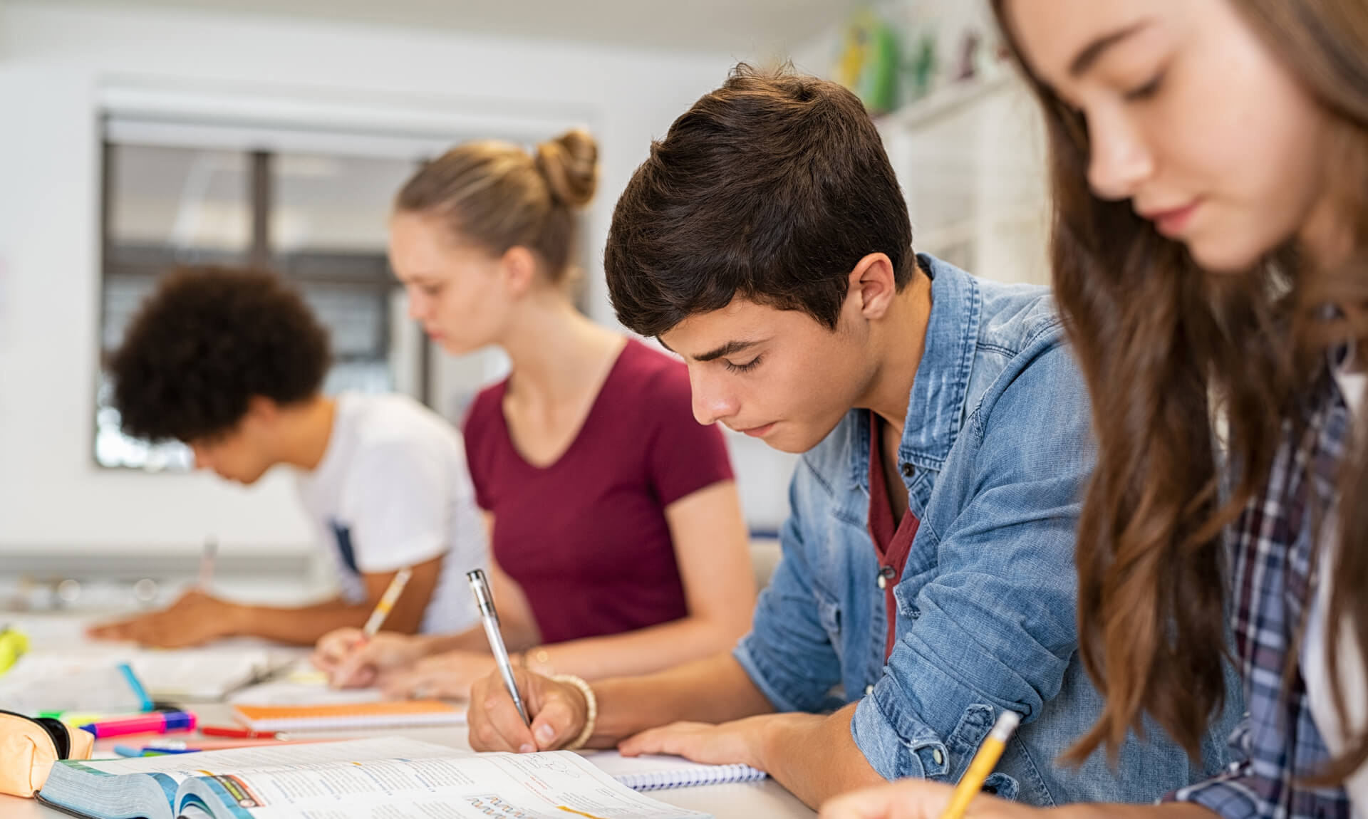 High school students doing exam in classroom.