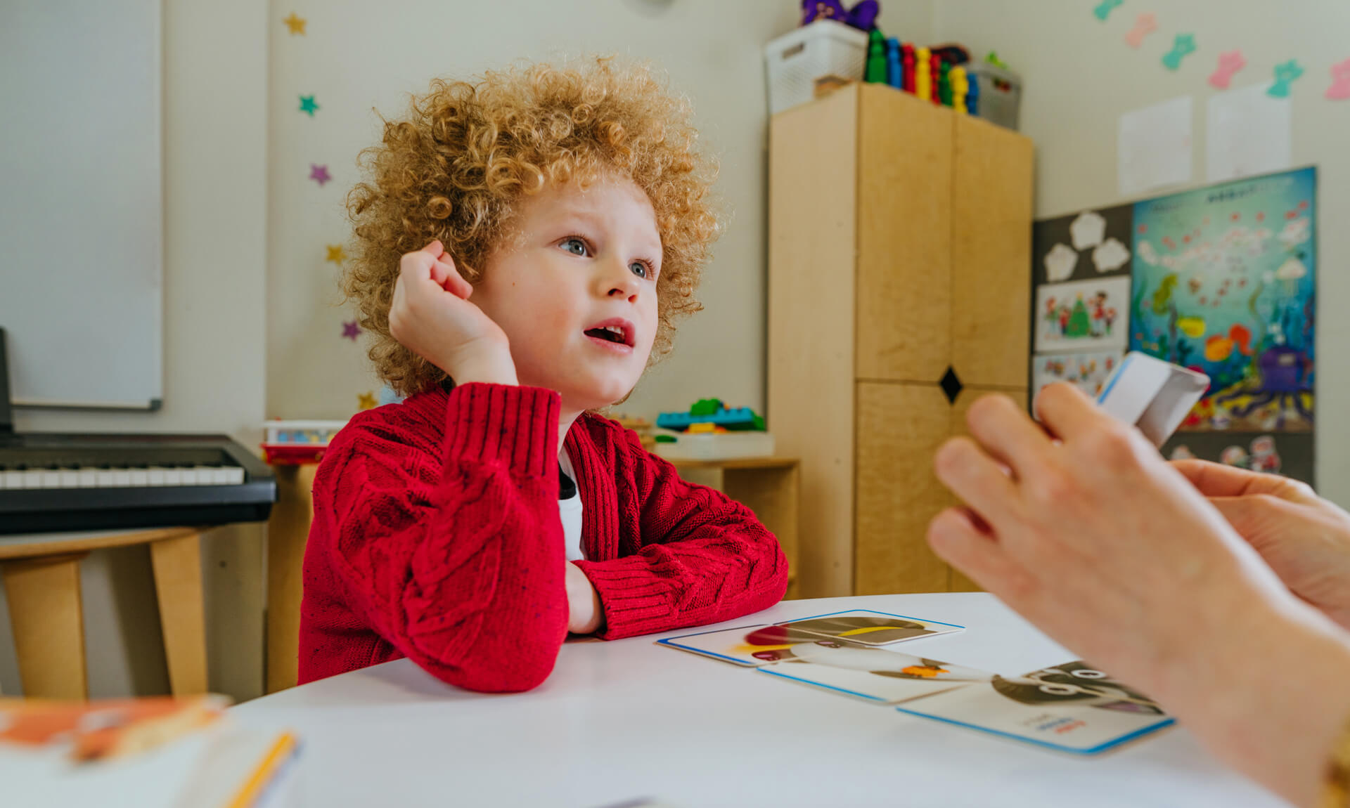 Teacher spreads out puzzle in front of child.