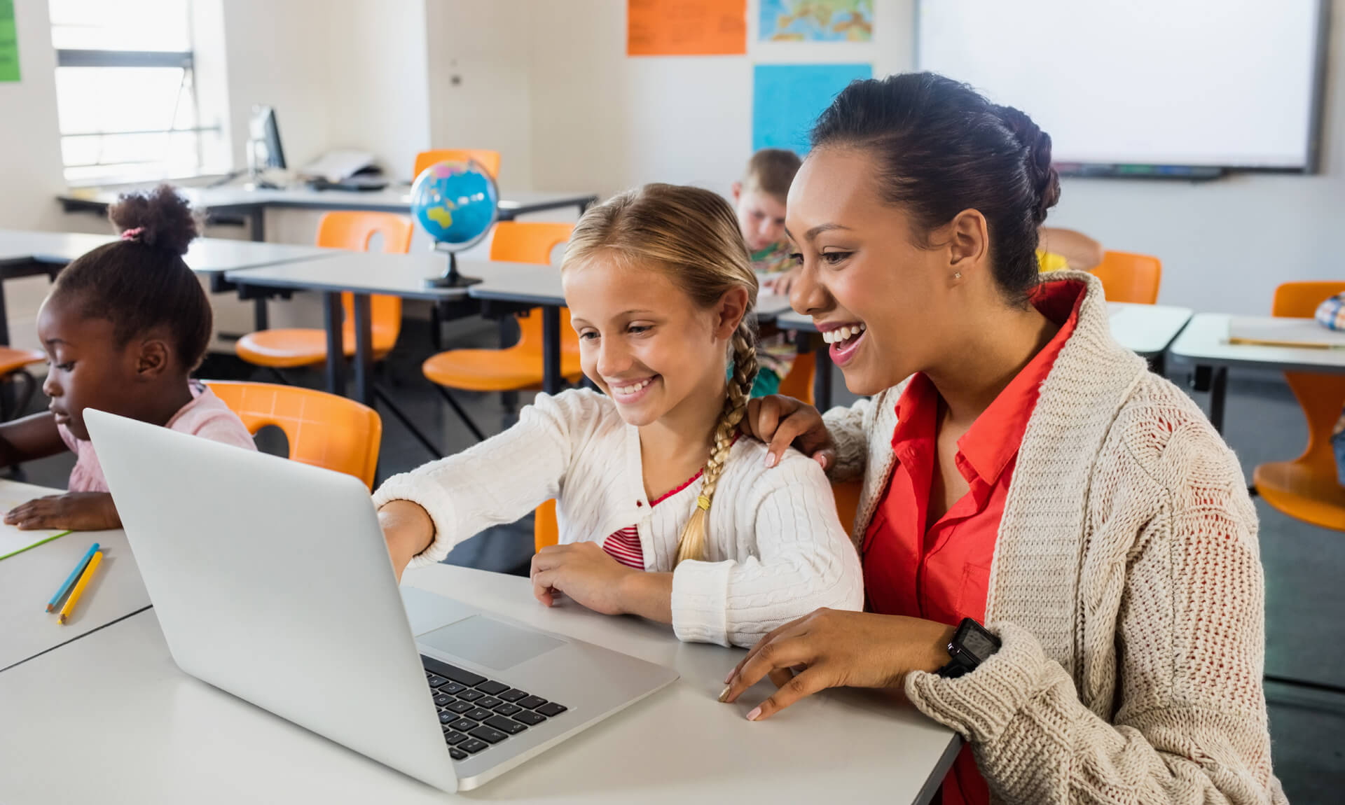 teacher helping student with laptop