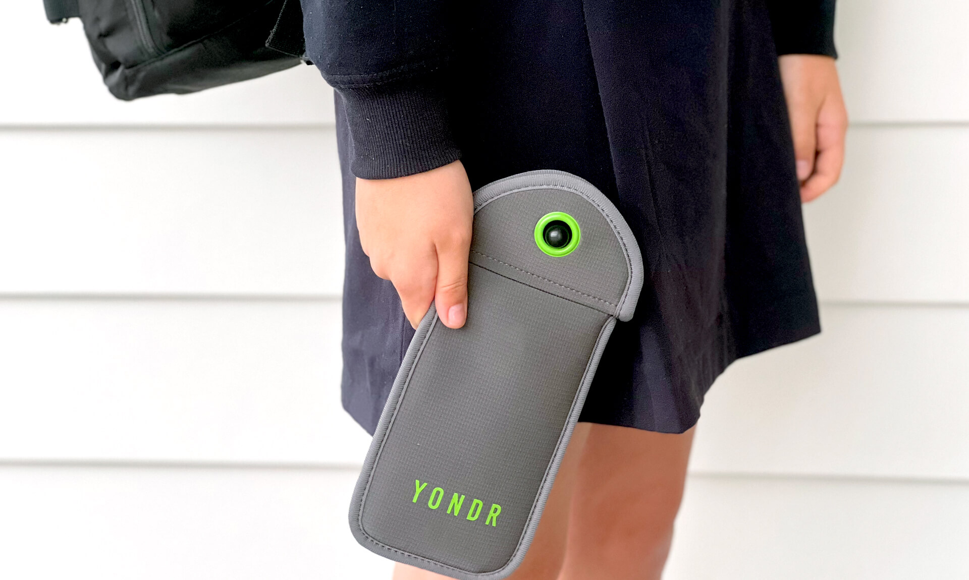 Student holding a lockable cellphone pouch used in schools to limit phone access during the school day.